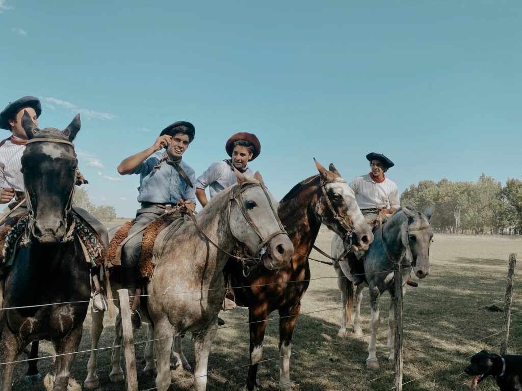 Travelers horseback riding through the Argentine countryside on a sunny day
